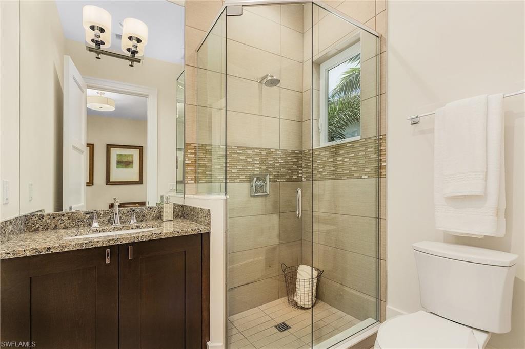 9149 Mercato Way Naples, FL 34108 - Photo 31 of 47 a bathroom with a granite countertop sink a toilet and shower
