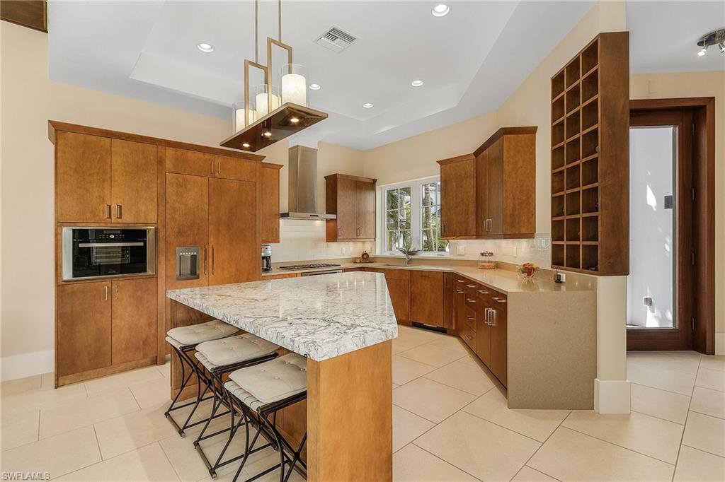 9149 Mercato Way Naples, FL 34108 - Photo 7 of 47 a kitchen with stainless steel appliances granite countertop a sink counter space cabinets and a refrigerator