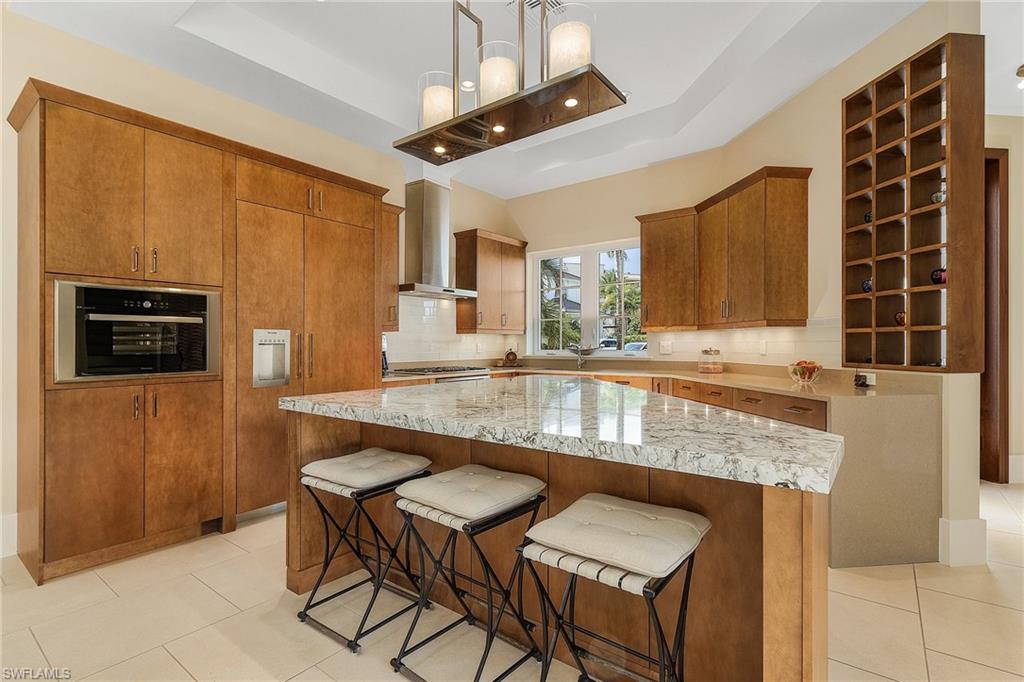 9149 Mercato Way Naples, FL 34108 - Photo 8 of 47 a kitchen with granite countertop sink table and chairs