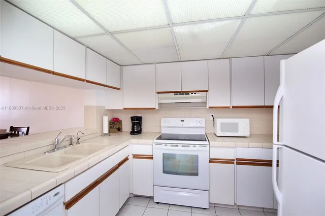 a kitchen with stainless steel appliances a sink a stove a refrigerator and cabinets