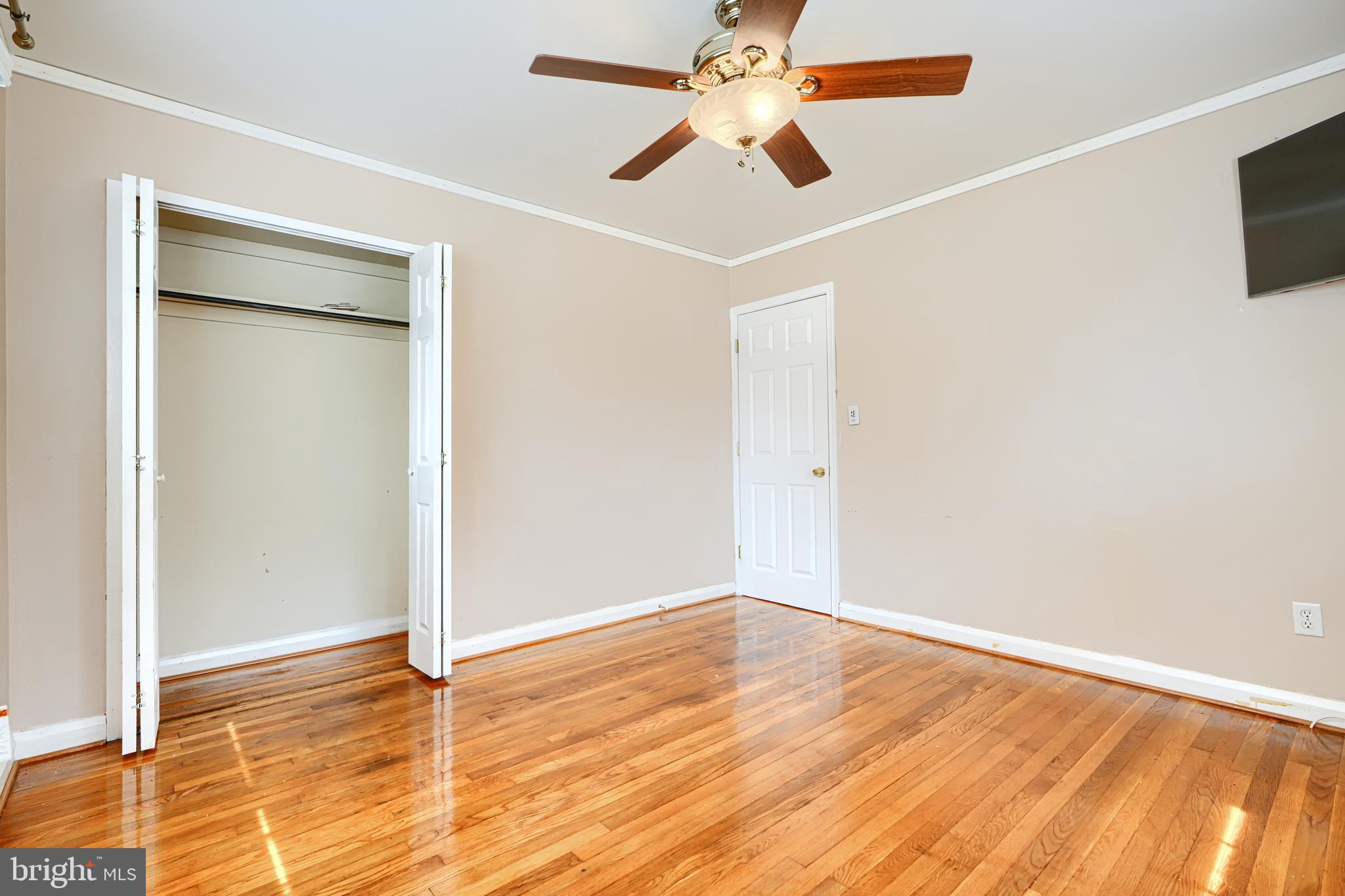 930 Sedgley Road Baltimore, MD 21228 - Photo 32 of 43 an empty room with wooden floor and a ceiling fan