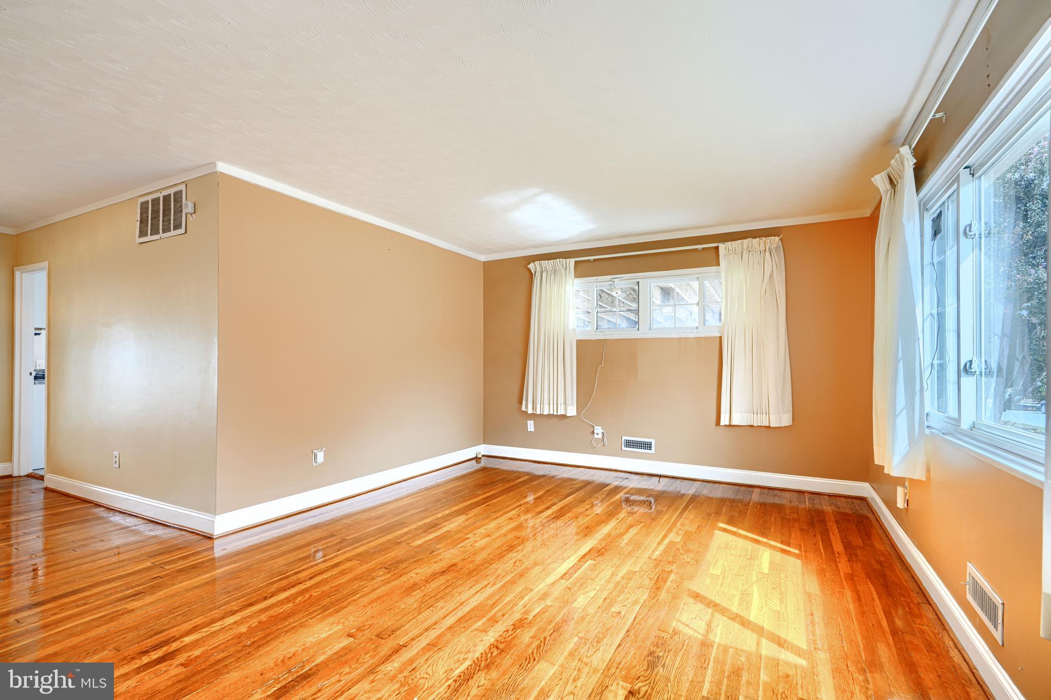 930 Sedgley Road Baltimore, MD 21228 - Photo 5 of 43 a view of an empty room with window and wooden floor