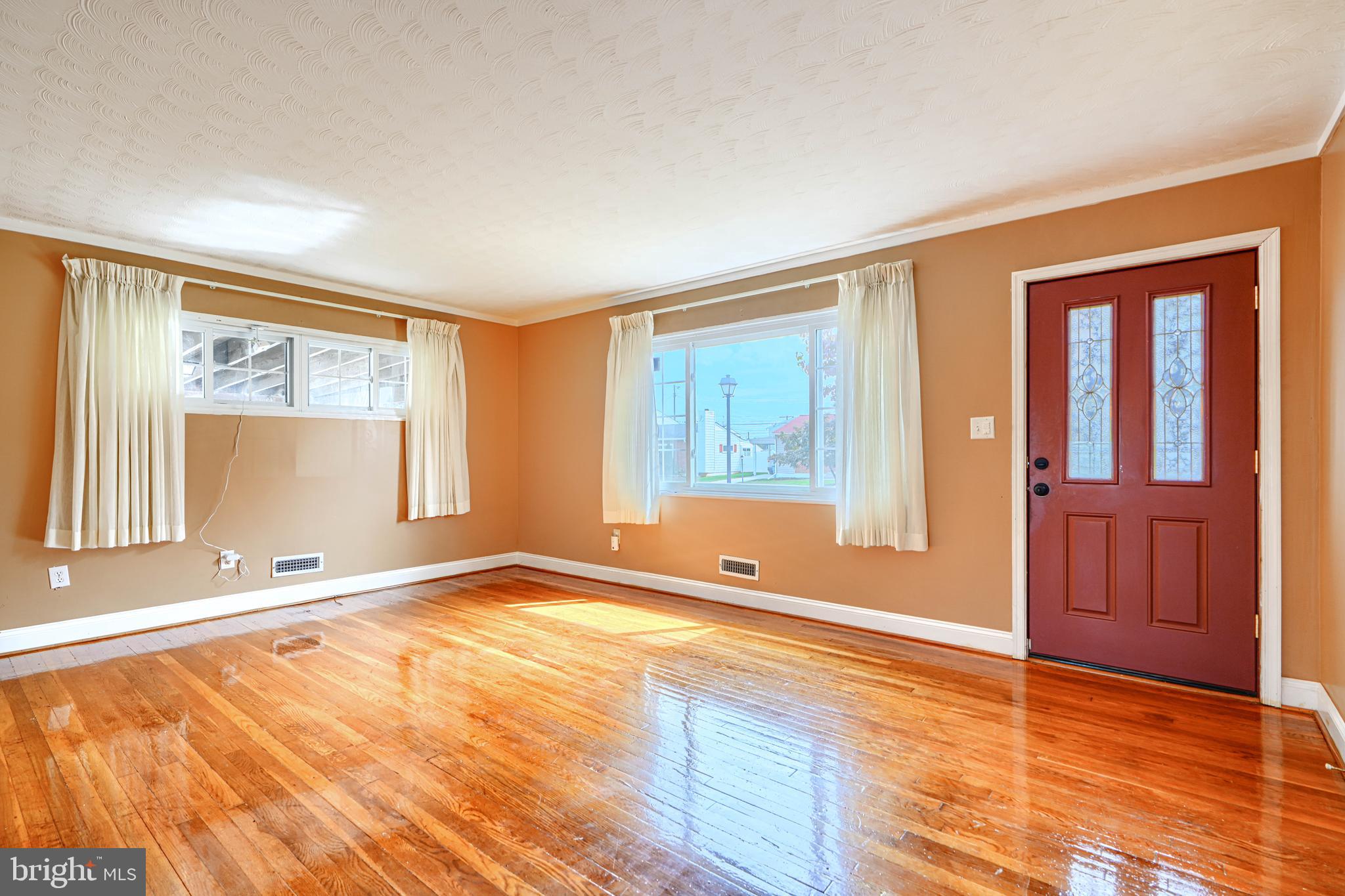 930 Sedgley Road Baltimore, MD 21228 - Photo 7 of 43 an empty room with wooden floor and windows