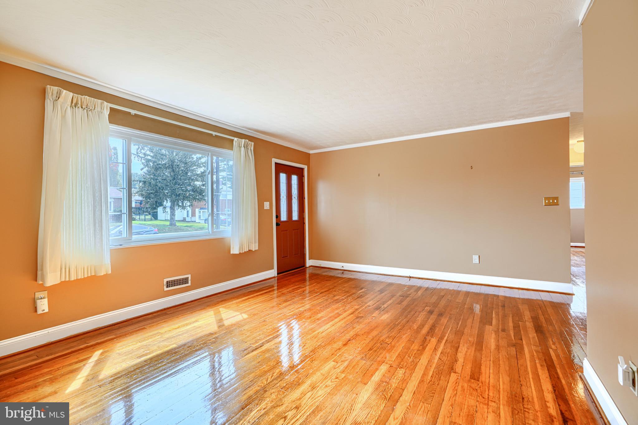 930 Sedgley Road Baltimore, MD 21228 - Photo 8 of 43 a view of an empty room with wooden floor and a window