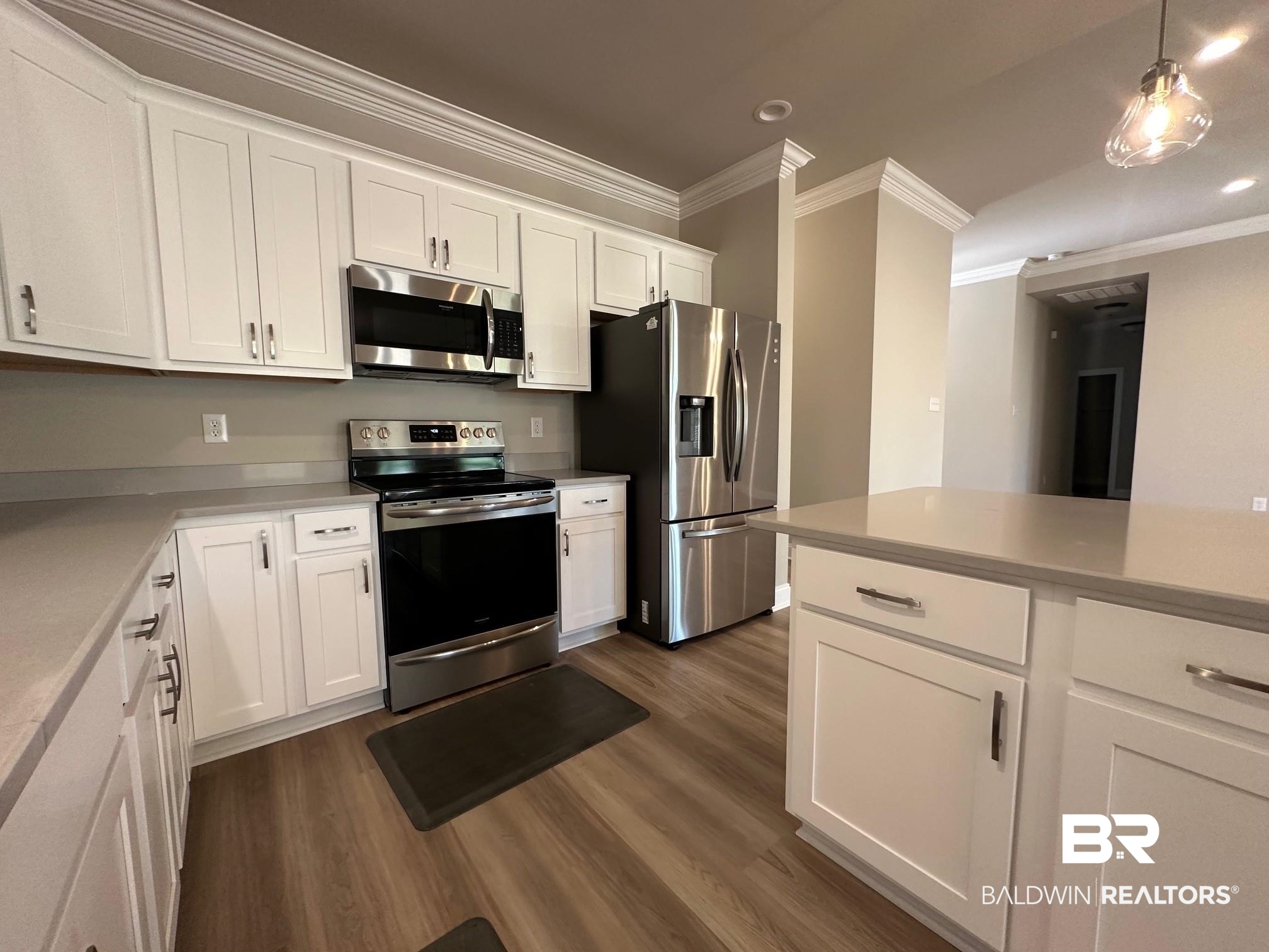 1009 Ruisseau Drive Foley, AL 36535 - Photo 32 of 55 Kitchen featuring dark hardwood / wood-style floors, hanging light fixtures, ornamental molding, white cabinets, and appliances with stainless steel finishes
