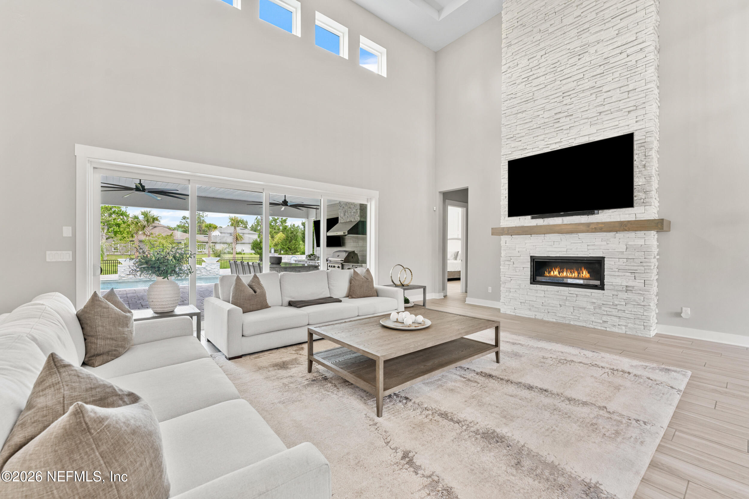 245 Ranch Land Circle St. Johns, FL 32259 - Photo 12 of 74 a living room with furniture a flat screen tv and a fireplace
