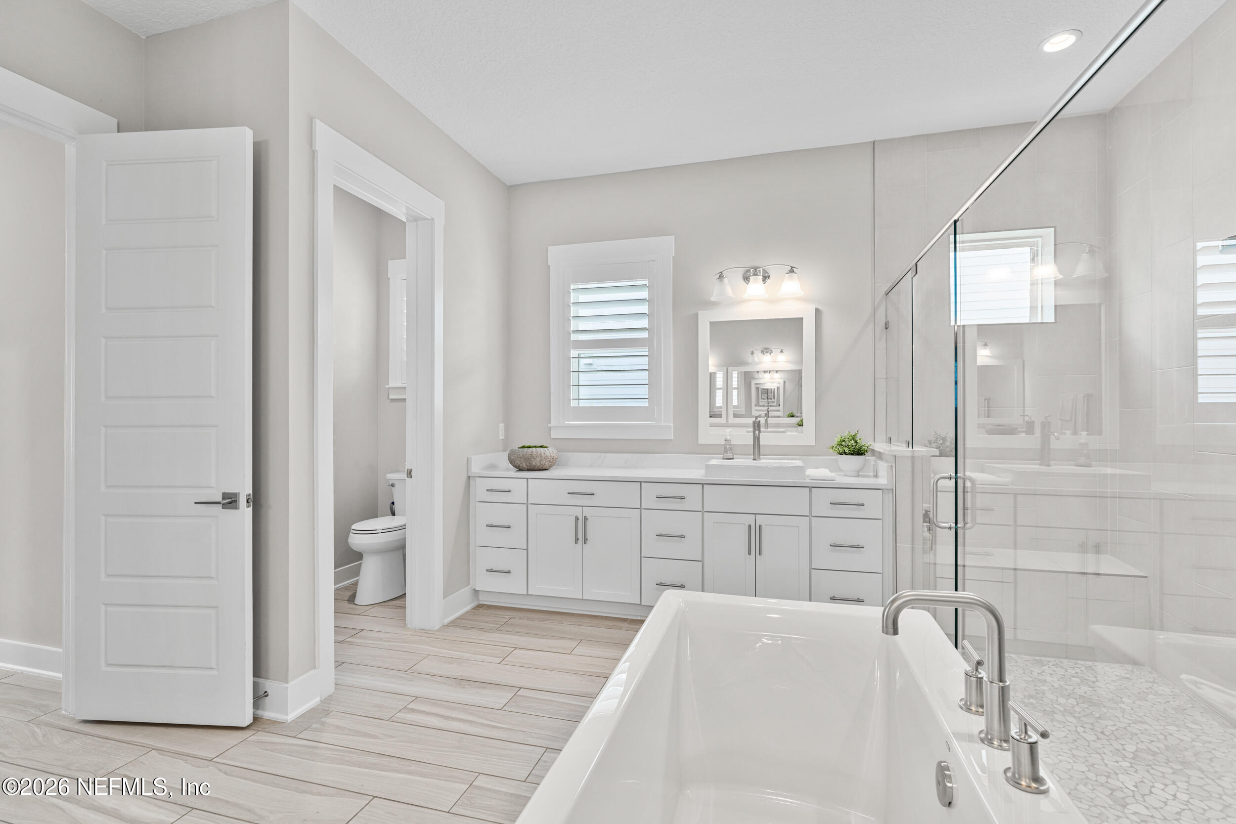 245 Ranch Land Circle St. Johns, FL 32259 - Photo 27 of 74 a spacious bathroom with a granite countertop sink a toilet a mirror and shower