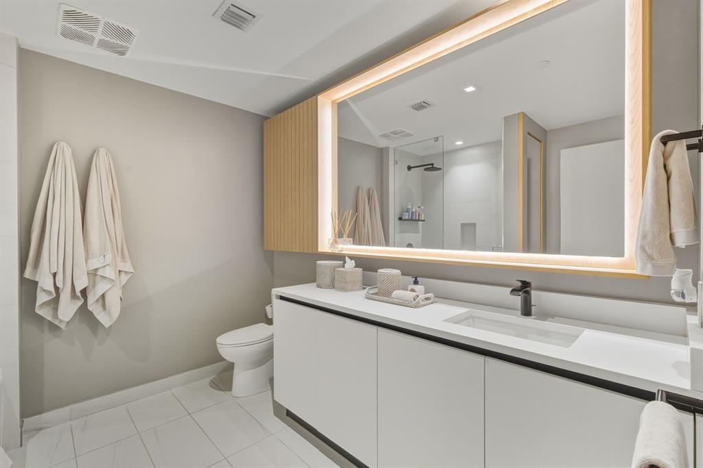 1116 North Ocean Boulevard, Unit 1506 Pompano Beach, FL 33062 - Photo 35 of 69 a bathroom with a double vanity sink and a mirror