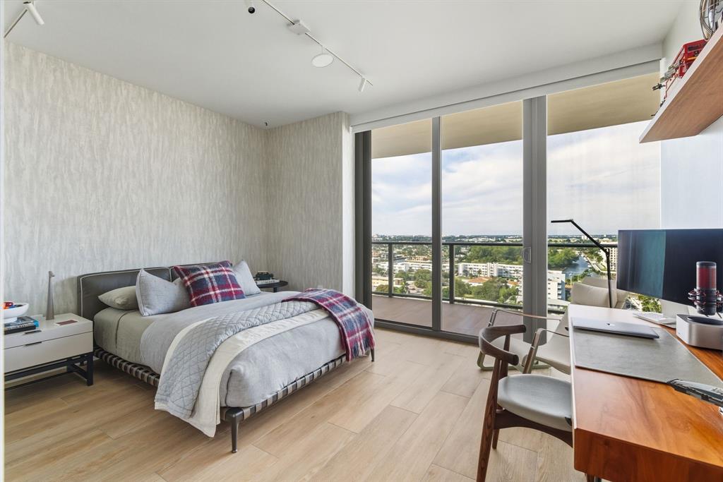 1116 North Ocean Boulevard, Unit 1506 Pompano Beach, FL 33062 - Photo 46 of 69 a bedroom with a bed and a large window with wooden floor