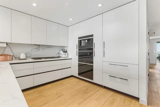 a kitchen with a refrigerator and white cabinets