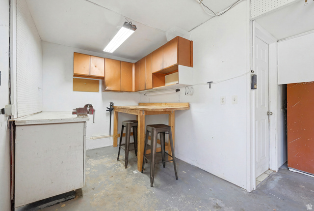 1486 3rd Street Ogden, UT 84404 - Photo 20 of 26 Dedicated workspace featuring wood-finish upper cabinetry, a built-in wood-finish workbench, and a white lower cabinet
