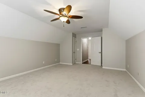 an empty room with chandelier fan