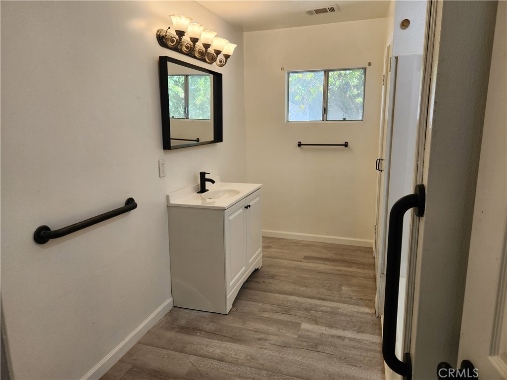 12690 7th Street Yucaipa, CA 92399 - Photo 6 of 7 a bathroom with a sink a mirror and a window