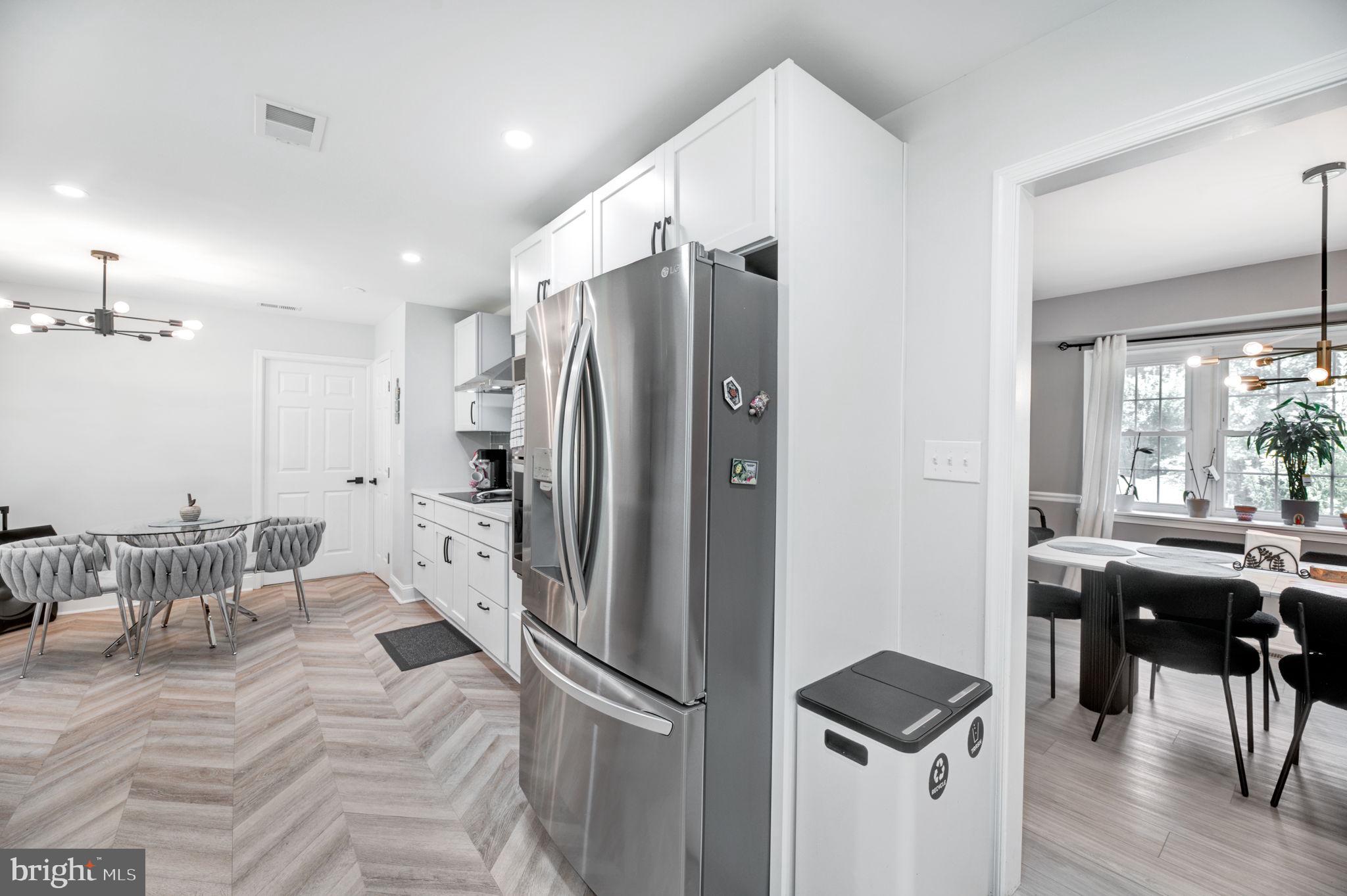 8812 Churchfield Lane Laurel, MD 20708 - Photo 8 of 31 a kitchen with stainless steel appliances refrigerator stove and table