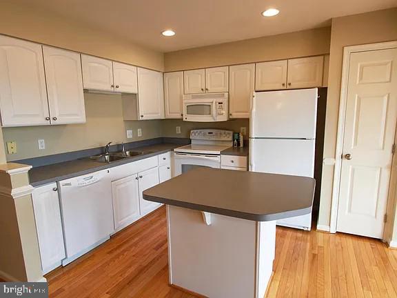 1336 Steed Street Ranson, WV 25438 - Photo 6 of 15 a kitchen with granite countertop a refrigerator a stove a sink and white cabinets with wooden floor