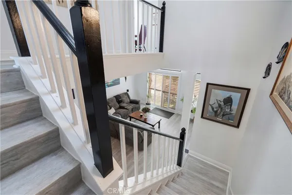 a view of staircase with lots of frames on wall and a window
