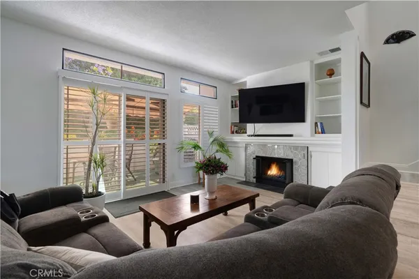 a living room with furniture a flat screen tv and a fireplace