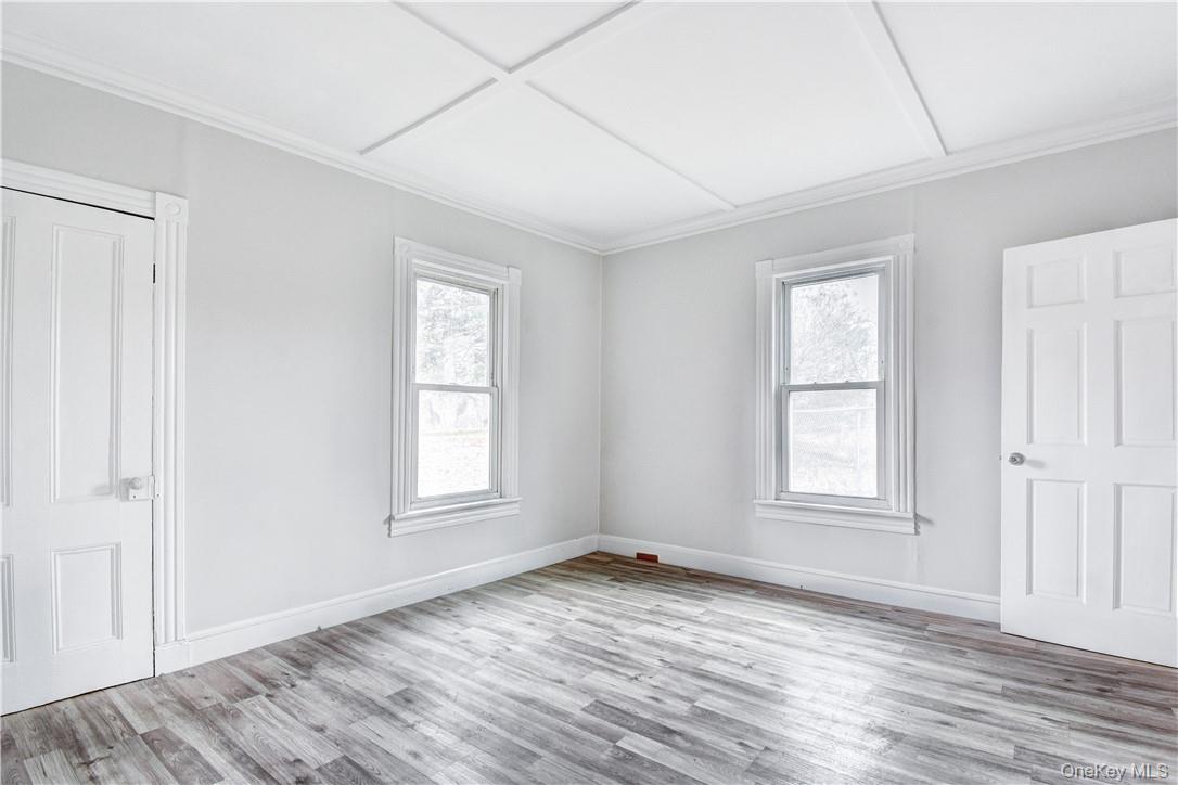 202 Midland Lake Road Middletown, NY 10941 - Photo 7 of 26 an empty room with wooden floor and windows