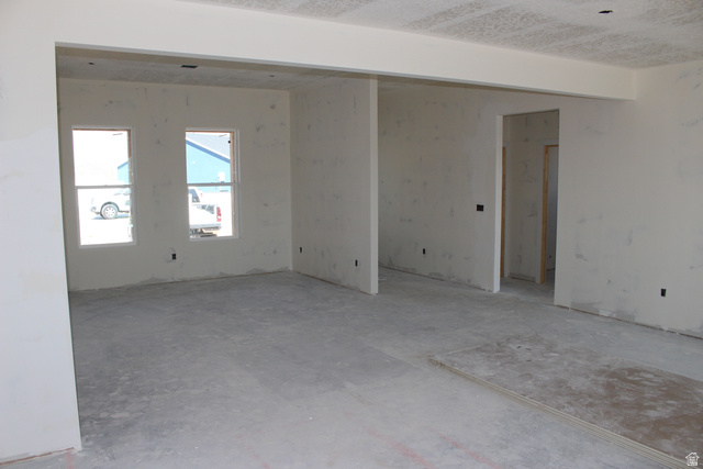 4933 East Remington Road Cedar City, UT 84721 - Photo 11 of 33 Spacious unfinished interior featuring a concrete floor, two large windows, and a partially framed doorway