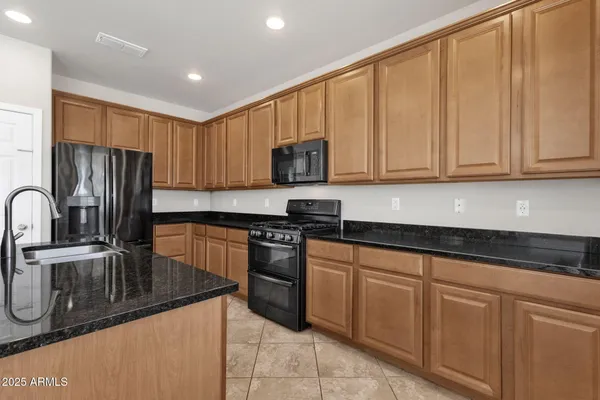a kitchen with stainless steel appliances granite countertop a stove refrigerator and a microwave