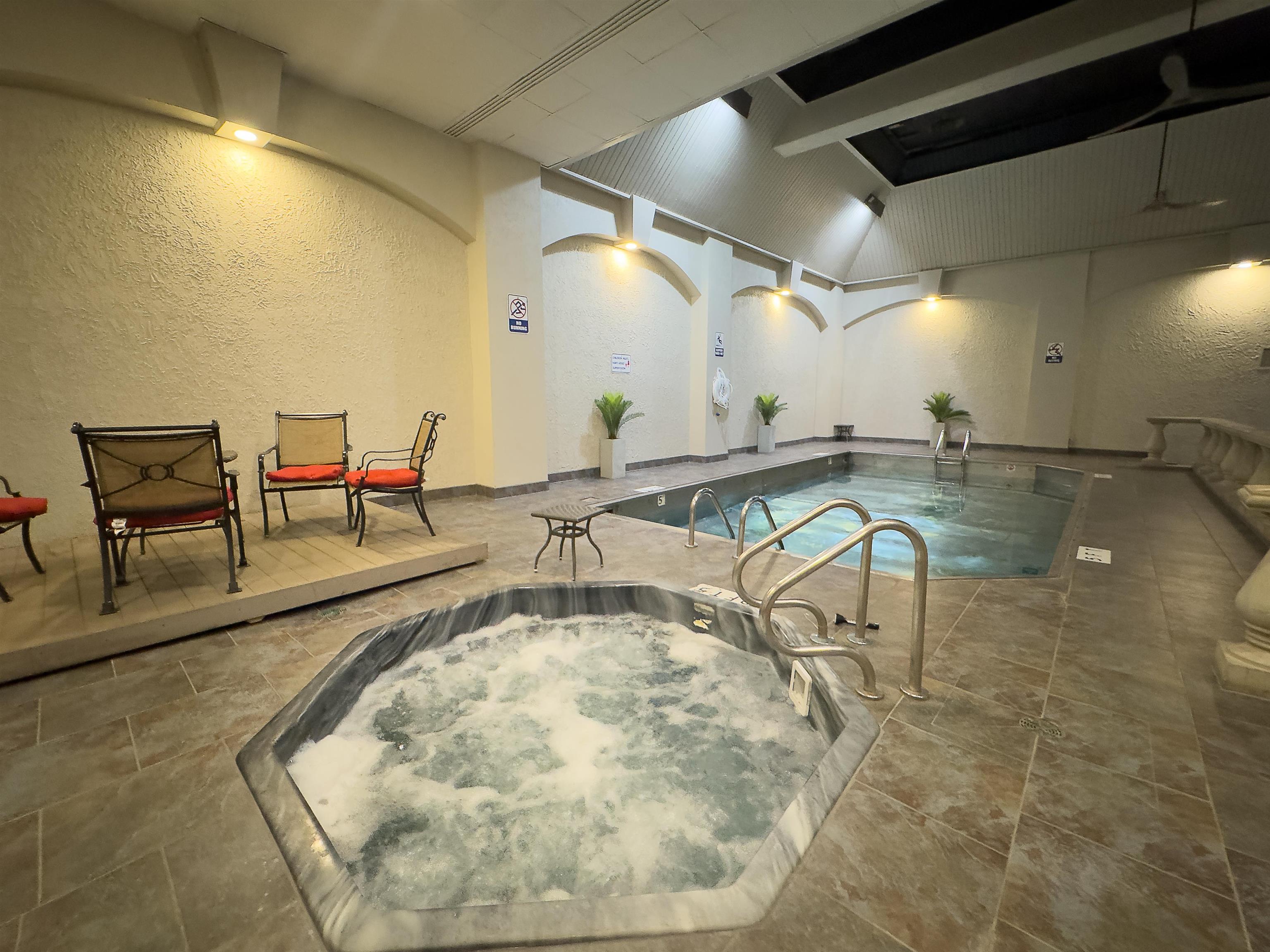 109 North Main Street, Unit 907 Memphis, TN 38103 - Photo 26 of 29 Indoor aquatic area featuring a rectangular swimming pool, an octagonal hot tub with integrated steps, and light-toned floor tiling