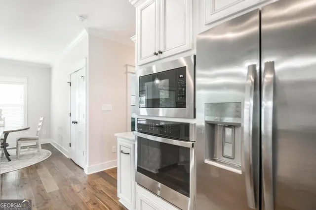 a kitchen with granite countertop a refrigerator and a stove top oven