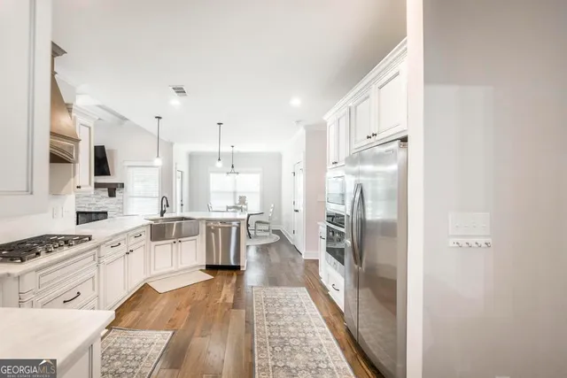 a kitchen with a refrigerator and a stove top oven