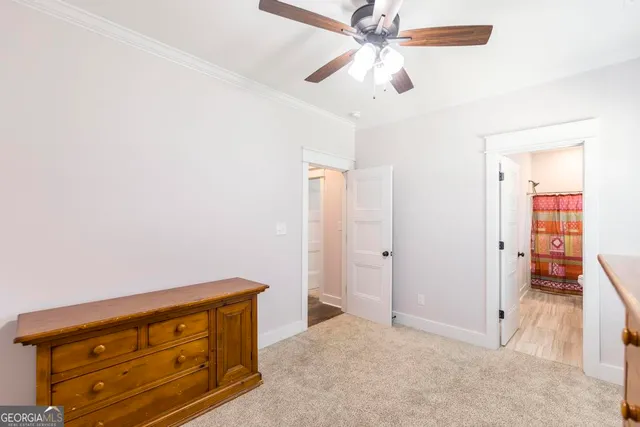 an empty room with closet and a ceiling fan
