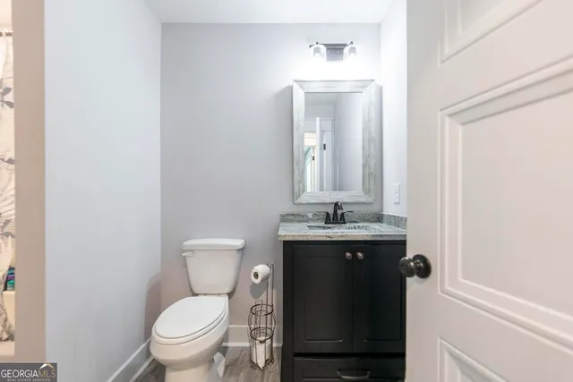 a bathroom with a toilet a sink and mirror