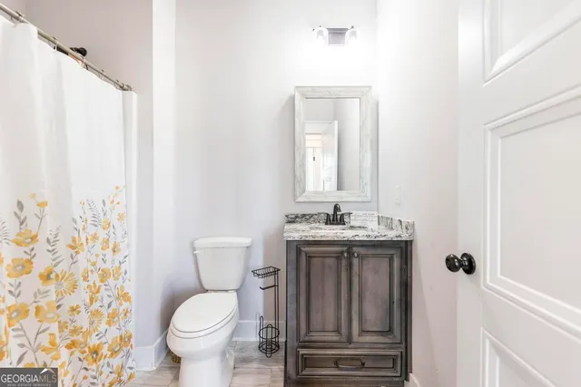 a bathroom with a toilet sink and mirror
