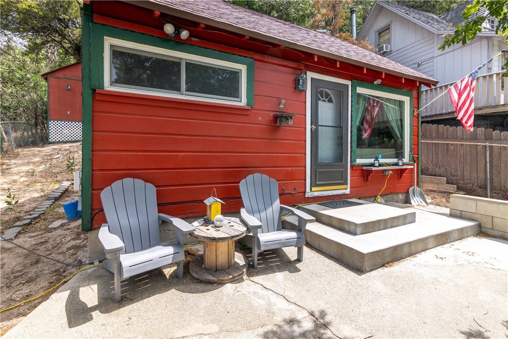 23526 Knapps Cutoff Crestline, CA 92325 - Photo 1 of 30 a view of a patio with couple of chairs and a fire pit