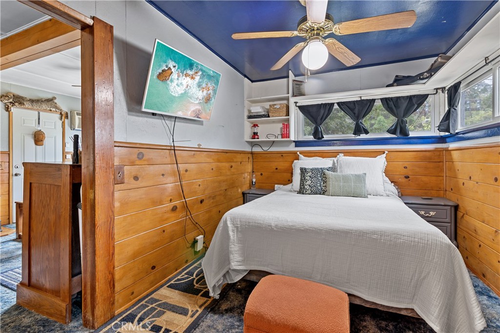 23526 Knapps Cutoff Crestline, CA 92325 - Photo 16 of 30 a bedroom with a bed and a flat screen tv