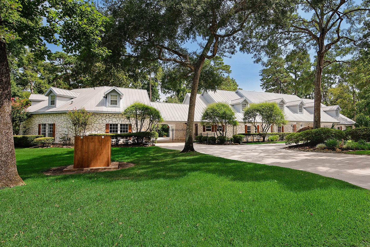 Sprawling estate has fine appointments with metal roof, dormers, stone, custom shutters and front porch add charm, character and excellent curb appeal.