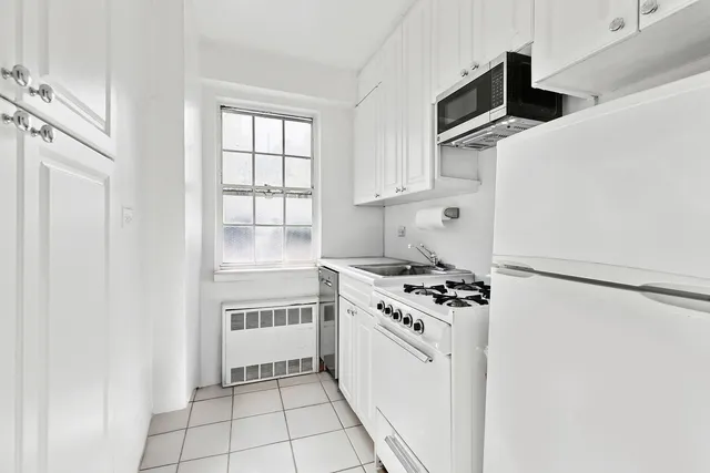 a kitchen with white cabinets and white appliances