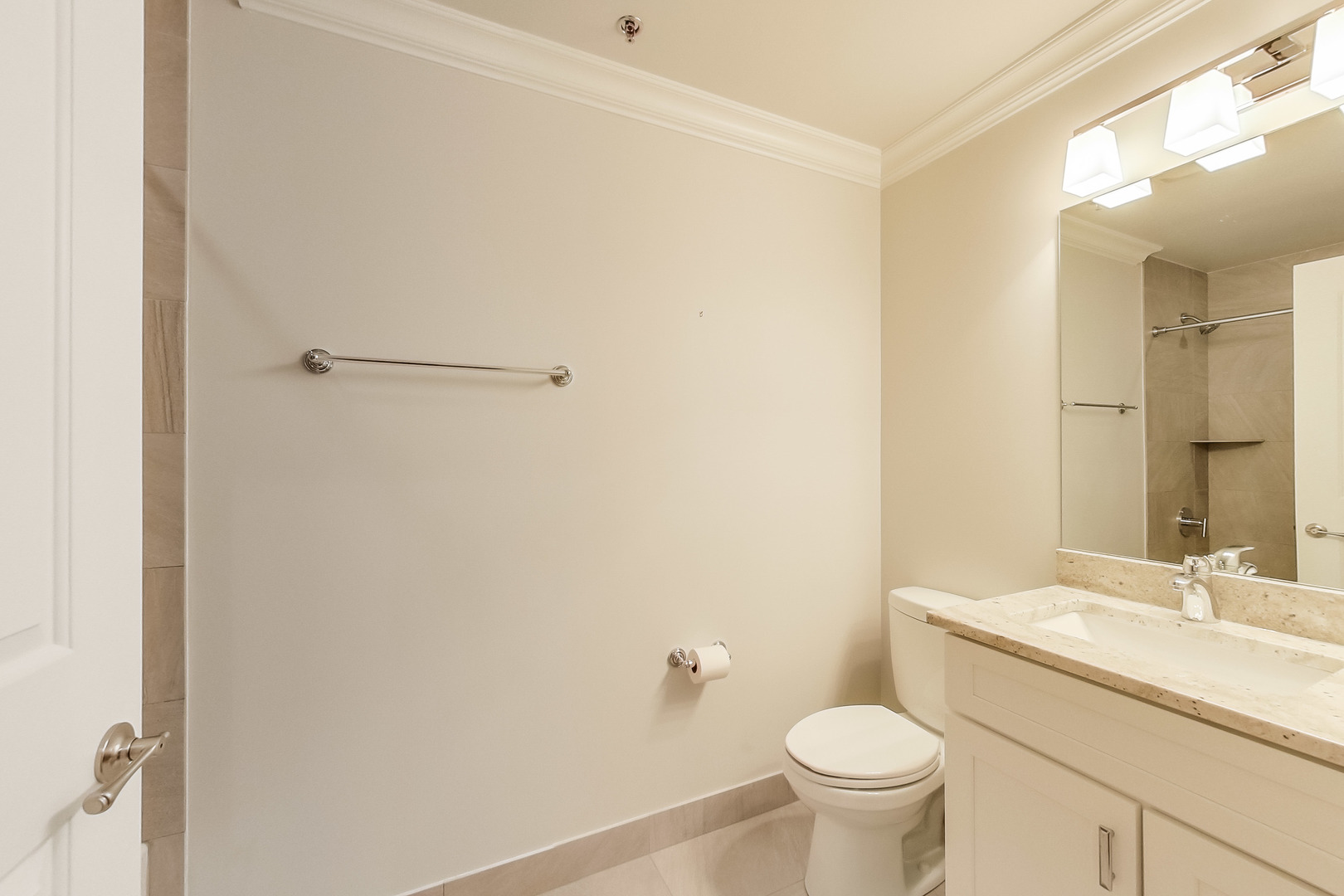 1247 West Madison Street, Unit 212 Chicago, IL 60607 - Photo 12 of 12 a bathroom with a granite countertop toilet a sink and a mirror