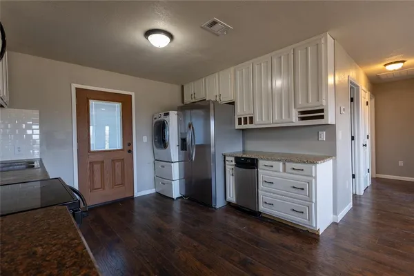 a kitchen with granite countertop wooden floors and stainless steel appliances