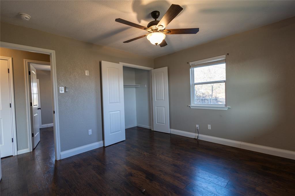 5780 Randle Road Granbury, TX 76049 - Photo 7 of 16 a view of an empty room with wooden floor and a ceiling fan