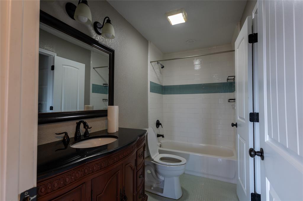5780 Randle Road Granbury, TX 76049 - Photo 9 of 16 a bathroom with a granite countertop sink toilet and shower