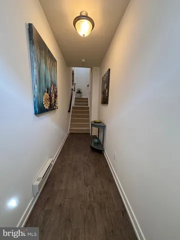 a view of a hallway with wooden floor and stairs
