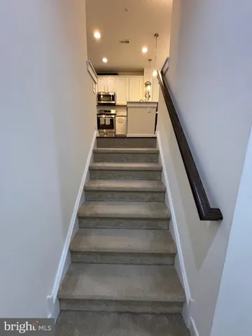 a kitchen with granite countertop a table chairs microwave and cabinets