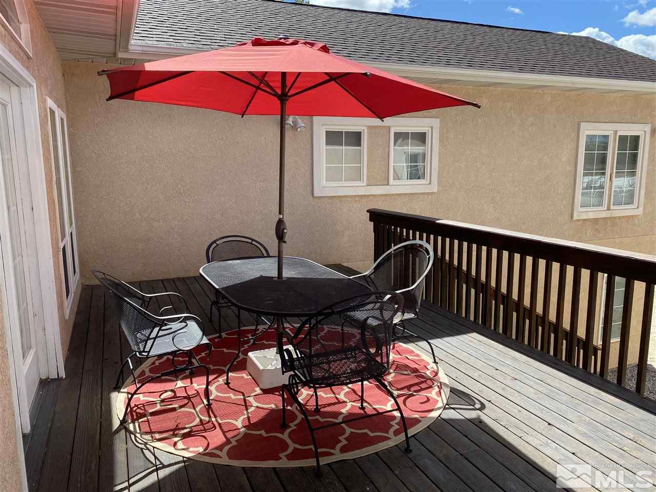 4111 Rancheria Road Fallon, NV 89406 - Photo 34 of 40 a view of a roof deck with table and chairs under an umbrella