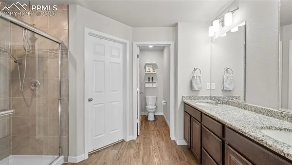 a spacious bathroom with a granite countertop sink a mirror and shower