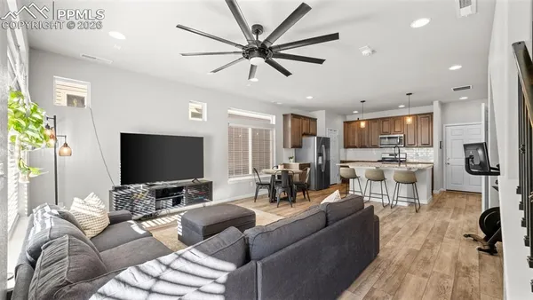 a living room with furniture and a flat screen tv with wooden floor
