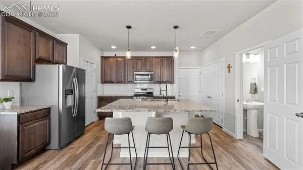 a kitchen with stainless steel appliances kitchen island granite countertop a refrigerator and a stove top oven