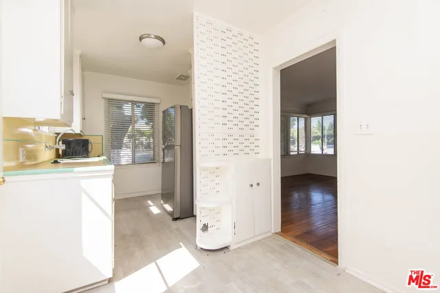 a view of a hallway with wooden floor and a living room