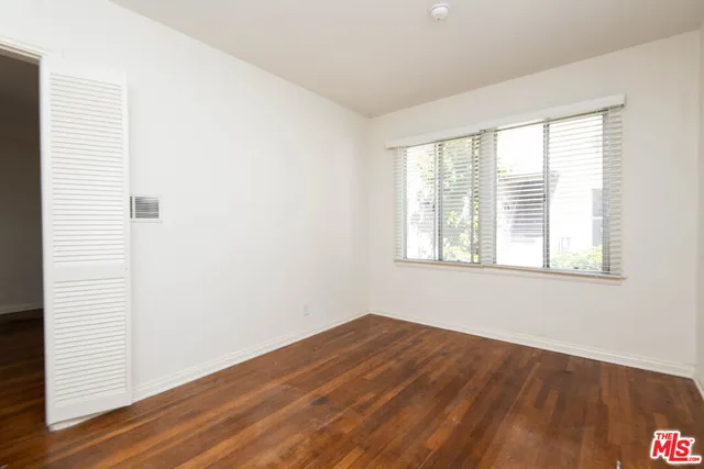 a view of a room with wooden floor and windows