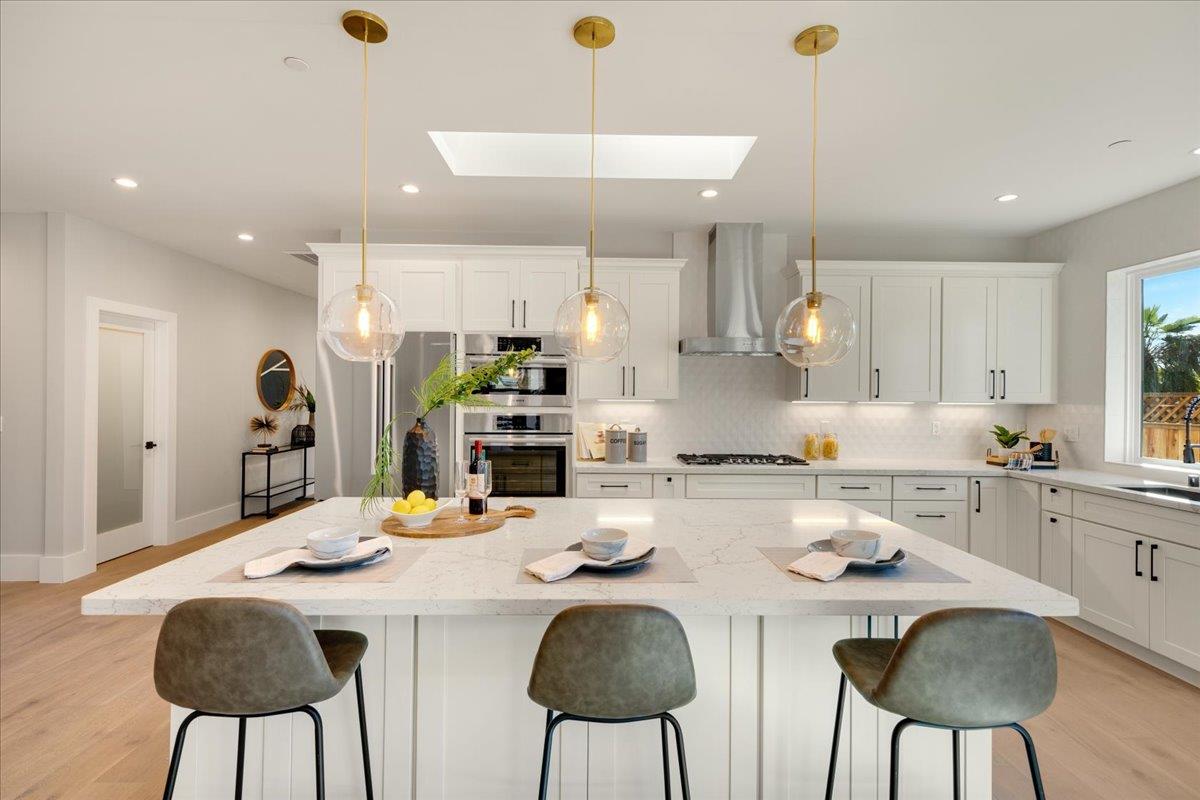 1472 South Wolfe Road Sunnyvale, CA 94087 - Photo 14 of 47 a kitchen with stainless steel appliances kitchen island granite countertop a dining table chairs and sink