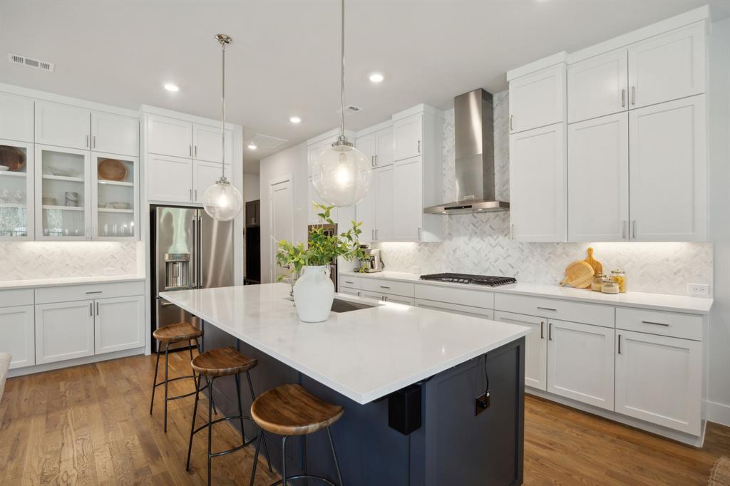 a kitchen with a sink a stove a refrigerator and white cabinets