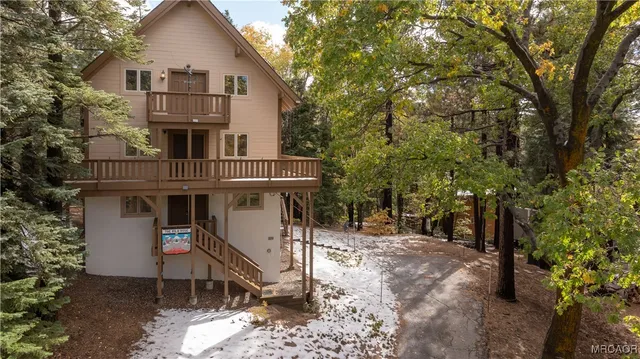 a view of a white house with large trees and outdoor space