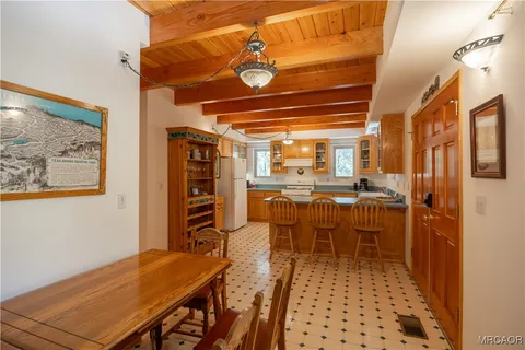 a dining area with furniture a rug and a painting
